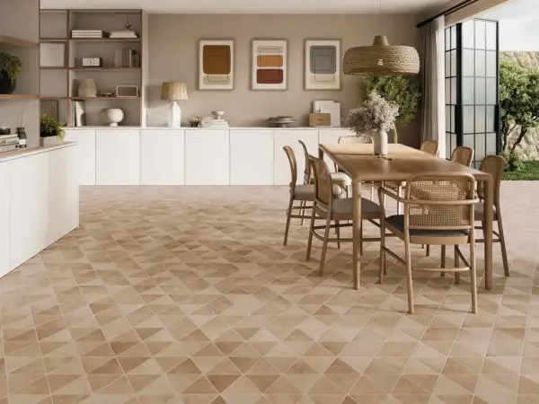 Un salon lumineux avec un carrelage non salissant au motif géométrique discret. Une table en bois et des chaises en rotin complètent l'ensemble.