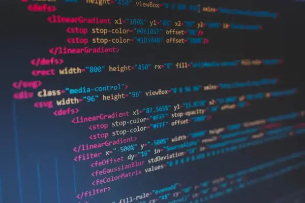 Kod SVG z definicjami gradientów i filtrów. Widać tu elementy takie jak `<linearGradient>`, `<filter>` i `<feColorMatrix>`, które tworzą złożone efekty wizualne, gdzie nawet **twarda spacja** ma znaczenie w strukturze kodu.