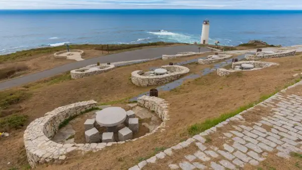 Faros de la Costa da Morte vigilando el Atlántico. Bancos de piedra y mesas invitan a contemplar el paisaje marino.