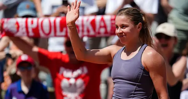 Maja Chwalińska, uśmiechnięta, macha do kibiców. W tle widać transparent z napisem "POLSKA".