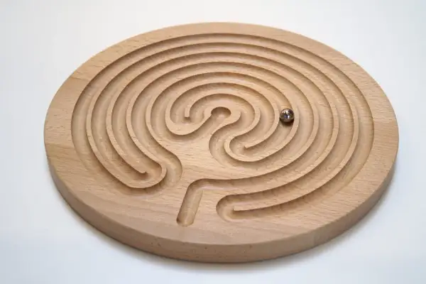 Okrągły, drewniany labirynt z metalową kulką w środku. Wyzwanie dla cierpliwych.