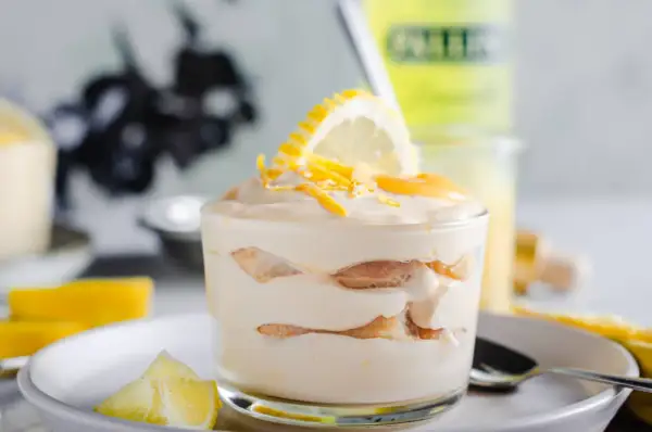 Un délicieux tiramisu limoncello, superposé de biscuits et de crème, garni d'une tranche de citron et de zestes.
