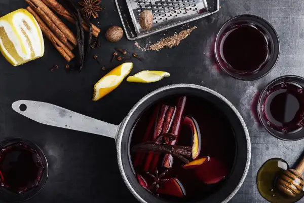 Aromatyczne wino z herbaty, z cynamonem, goździkami i skórką pomarańczy, gotowe do podania w szklankach.