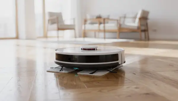 Robot lavapavimenti bianco e nero su parquet lucido. Non si può mettere alcool nel robot lavapavimenti.