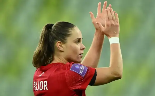 Piłkarka Ewa Pajor, z włosami spiętymi w kucyk, klaszcze w dłonie. Na jej ramieniu widnieje naszywka "Women's European Qualifiers".