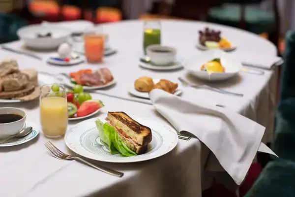 Frukostbordet på **Bonnies Bank Hotel** dukat med smörgås, frukt, juice, kaffe och croissanter.