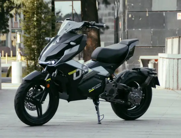 Moderna repro moto 125 eléctrica, negra y futurista, aparcada en la calle.