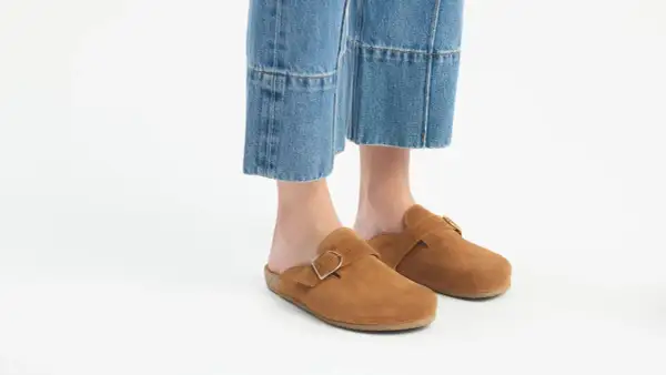 Brązowe zamszowe klapki z klamrą idealnie pasują do jeansów mom. Stylowe i wygodne buty na co dzień.