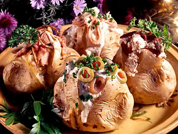 Fyra läckra bakade potatisar med olika fyllningar, toppade med gräddfil, bacon, oliver och örter. En festlig och mättande rätt!