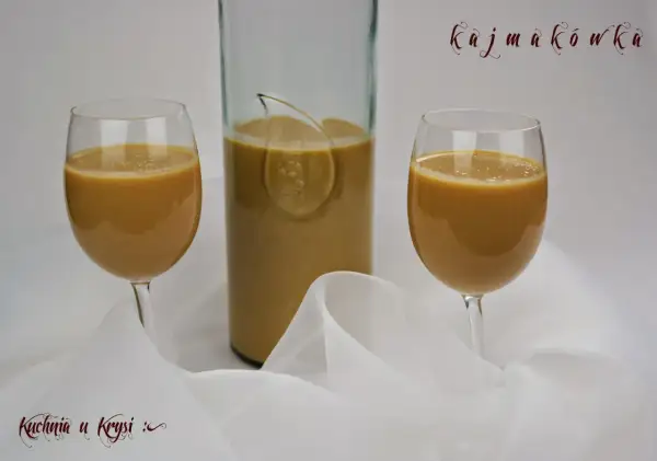 Kajmakówka, czyli likier krówkowy z masy kajmakowej, w kieliszkach i butelce, na tle białej tkaniny.