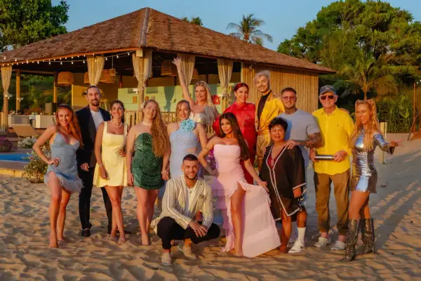 Die Besetzung von "Kampf der Realitystars" posiert am Strand vor einer Hütte.