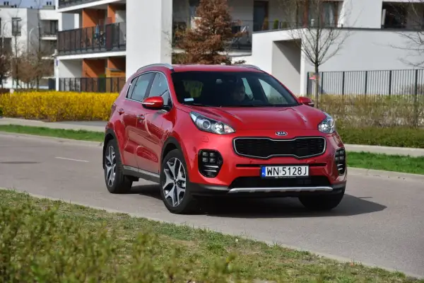 Czerwony Kia Sportage 4 na drodze, gotowy do wymiany żarówki.