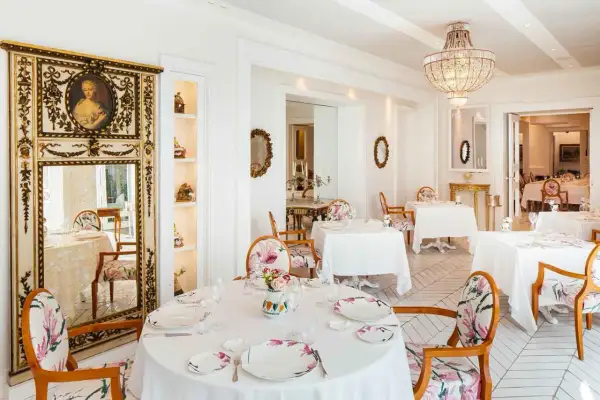 Eleganza e raffinatezza nel ristorante Don Alfonso, dove le stelle Michelin brillano in un ambiente da sogno con arredi floreali e un maestoso lampadario.
