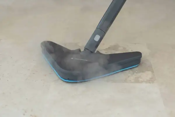 Dampfreiniger mit Dampf auf hellem Laminatboden.