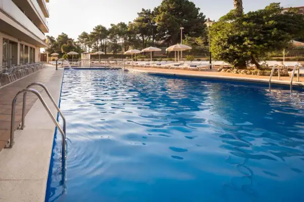 Basen w Lloret de Mar we wrześniu. Idealna pogoda na relaks przy basenie, z leżakami i parasolami.
