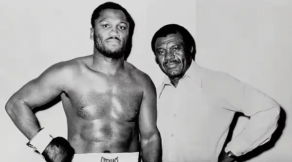 Joe Frazier, known for his impressive joe frazier height, stands with his trainer.