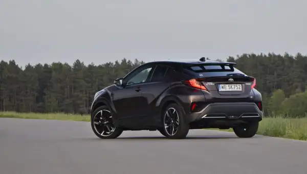 Ciemnobrązowa Toyota C-HR z czarnymi felgami na tle lasu. Czy to auto ma jakieś usterki?
