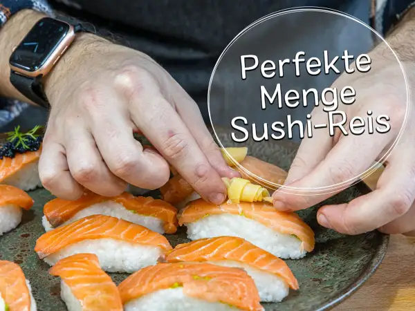 Hände arrangieren Sushi mit Lachs. Die perfekte Menge Sushi-Reis pro Person ist entscheidend für den Genuss.