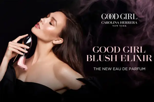 Kobieta zmysłowo wącha perfumy Carolina Herrera Good Girl Blush Elixir w różowym flakonie w kształcie szpilki.