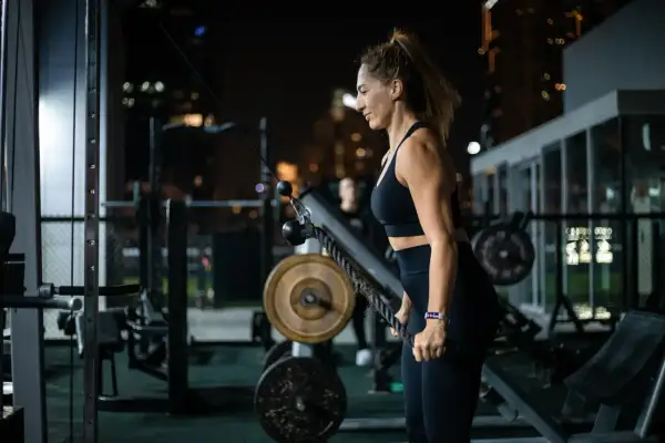 Kobieta ćwiczy na siłowni. Zastanawiasz się, ile kosztuje multisport dla firmy? To inwestycja w zdrowie pracowników.