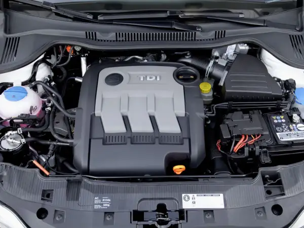 Silnik 1.4 TDI z widocznym napisem TDI na pokrywie. Widać elementy układu chłodzenia, akumulator i przewody.