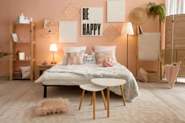 Sypialnia w stylu kawaii: łóżko z puszystymi kocami, poduszki w pastelowych kolorach, dekoracje ścienne z lampkami i napis "BE HAPPY".