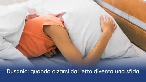Persona rannicchiata sotto le coperte, con la testa affondata nel cuscino. La difficoltà ad alzarsi la mattina può essere un sintomo di disania.