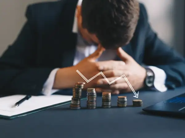 Zastanawiasz się, kto z polskich celebrytów ogłosił upadłość konsumencką w tym miesiącu? Obrazek pokazuje stosy monet i wykres spadkowy, symbolizujące problemy finansowe.