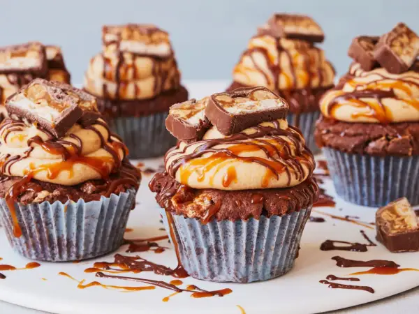 Schokoladen-Muffins mit Erdnussbutter-Frosting, Karamell und Snickers-Stücken. Diese Snickers Muffins sind ein Traum!