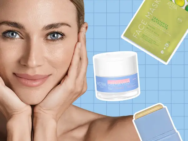 Donna con mani sul viso, circondata da prodotti Astra per la cura della pelle, per una skin longevity radiosa.