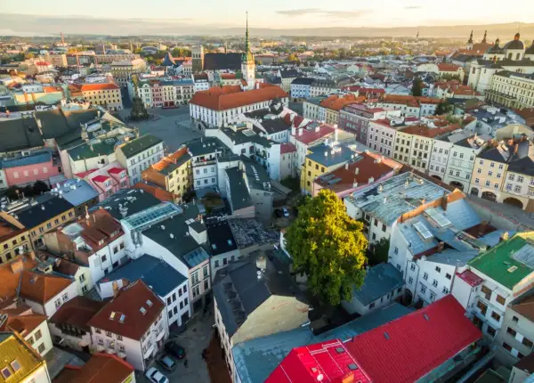 Blick über die Dächer von Olomouc, Tschechien, im goldenen Licht der Abendsonne. Bunte Häuser und historische Gebäude prägen das Stadtbild.