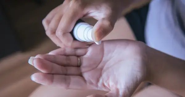 Dłoń aplikuje serum. Czy serum z witaminą C można używać latem? Tak, ale z ochroną przeciwsłoneczną.