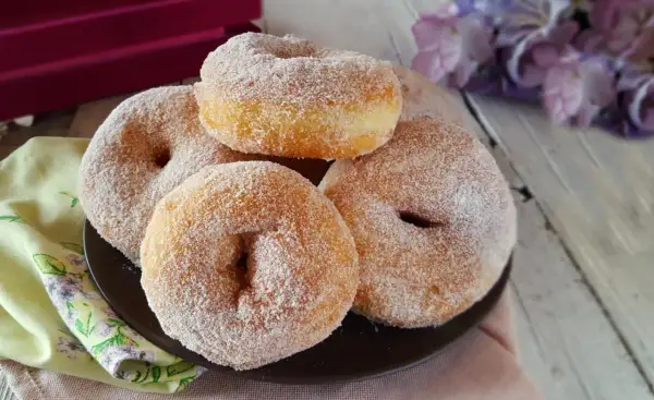 Graffe napoletane senza patate, soffici e dorate, ricoperte di zucchero. Un dolce che profuma di tradizione.