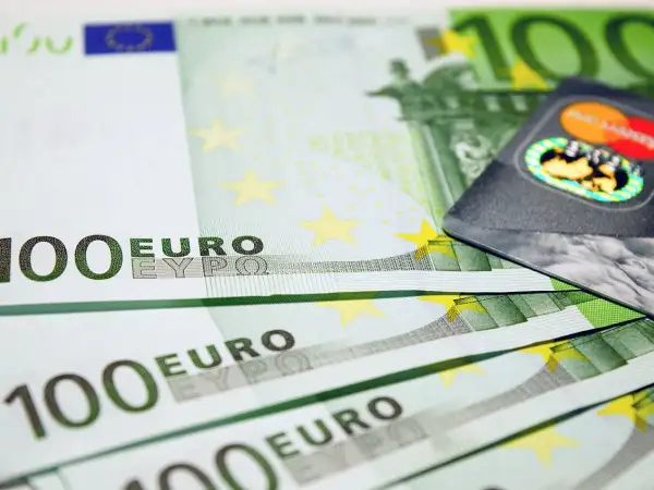 Banconote da 100 euro e una carta di credito, pronte per il rimborso spese.