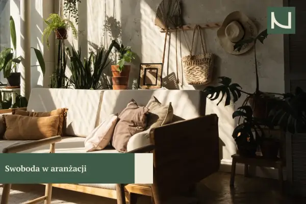 Przytulny salon w stylu boho z mnóstwem roślin, plecionymi dodatkami i słonecznymi promieniami.