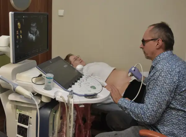 Lekarz wykonuje usg 3 trymestru. Na ekranie widać obraz płodu.