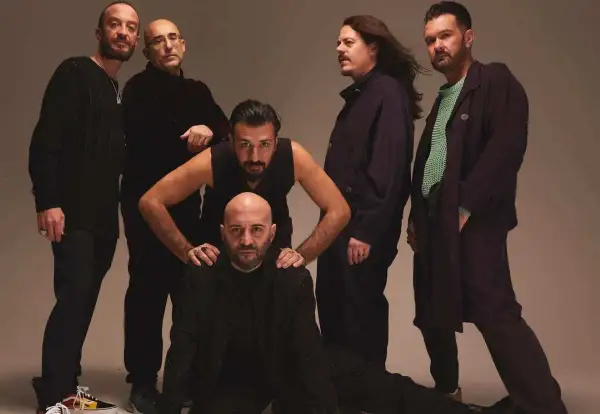 I Negramaro, in posa per "Quel posto che non c'è", sei uomini con sguardi intensi e abiti scuri.
