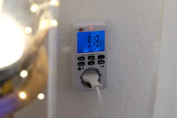 En brennenstuhl timer ansluten till ett vägguttag. Den digitala displayen visar tiden 9:13:54.