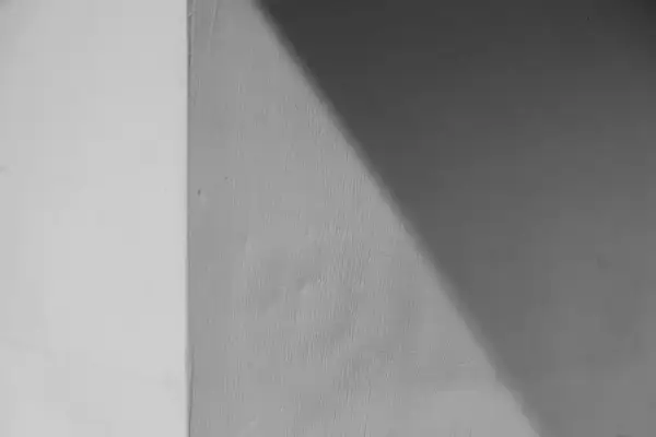 Ściana z widocznym podziałem na jaśniejszą i ciemniejszą część, o chropowatej fakturze. Wygląda jakby użyto klej zamiast tynku zewnętrznego.