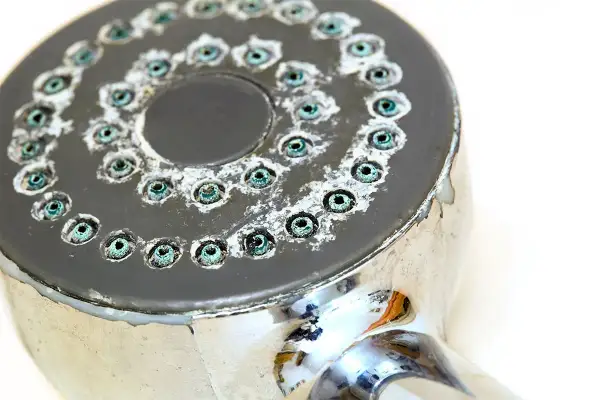 Soffione doccia incrostato di calcare, pronto per essere pulito. Scopri come pulire il soffione della doccia per un getto perfetto.