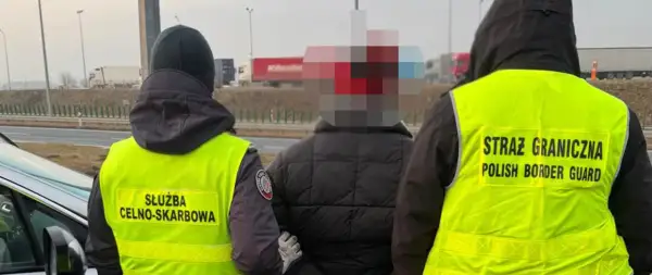 Funkcjonariusze Straży Granicznej i Służby Celno-Skarbowej zatrzymują osobę na drodze.