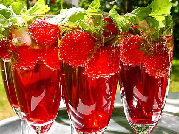 Tre glas med röd midsommar drink fyllda med jordgubbar och mynta. Perfekt för en varm sommardag.