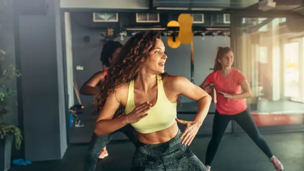 Kobiety tańczące w rytm muzyki na zajęciach zumba. To świetny sposób na aktywność fizyczną i dobrą zabawę.
