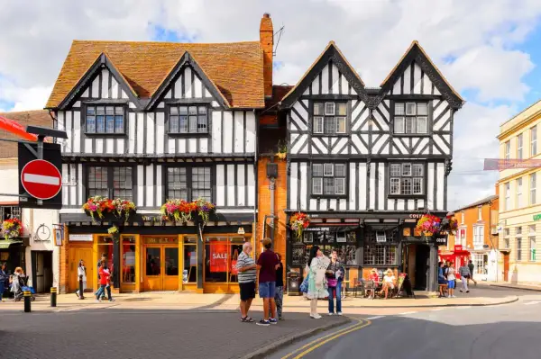 Urokliwe, zabytkowe budynki w Stratford-upon-Avon z charakterystyczną czarno-białą elewacją i kwiecistymi balkonami.