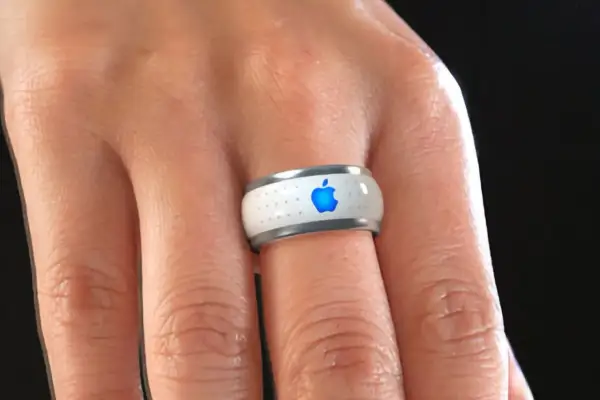 Bague connectée Apple, blanche avec logo bleu lumineux, portée au doigt.