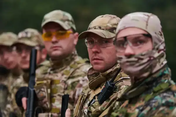 Kapral i jego drużyna w kamuflażu, gotowi do akcji. Wszyscy mają na sobie gogle ochronne i czapki.