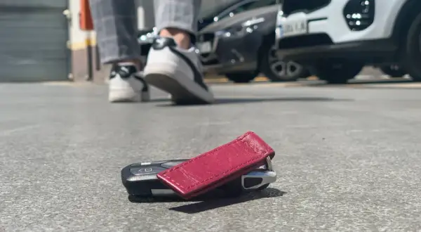 ¡Ay no! He perdido las llaves del coche. Están tiradas en el suelo, cerca de unos zapatos y coches aparcados.