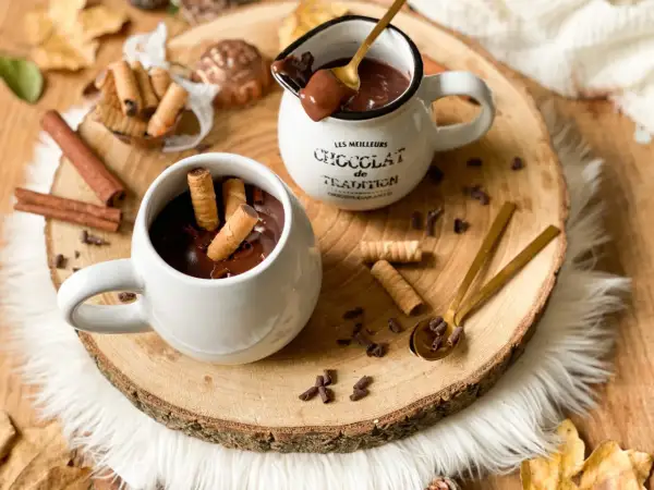 Cioccolata calda cremosa in tazza, con biscotti arrotolati e tavoletta di cioccolato. Un abbraccio goloso per le giornate autunnali.