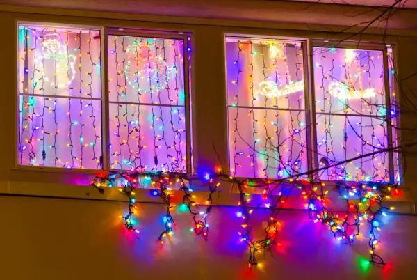 Kolorowe lampki świąteczne ozdabiają okna, tworząc magiczny nastrój. Dowiedz się, jak powiesić lampki na oknie, by uzyskać podobny efekt.