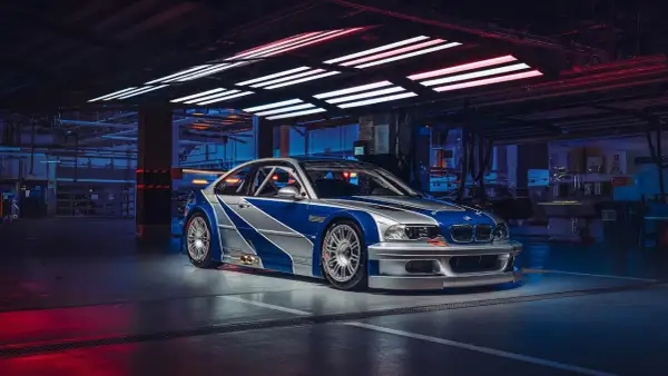 Wyścigowe e46 BMW M3 GTR w garażu, z niebiesko-srebrnym malowaniem, gotowe do akcji.
